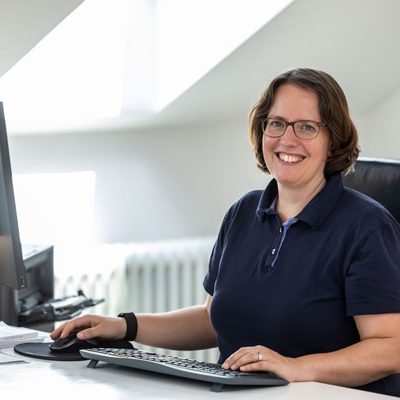 Porträt Ärztin Ines Michelsen-Wissen am Schreibtisch, Hausarztpraxis Aachen Mitte.