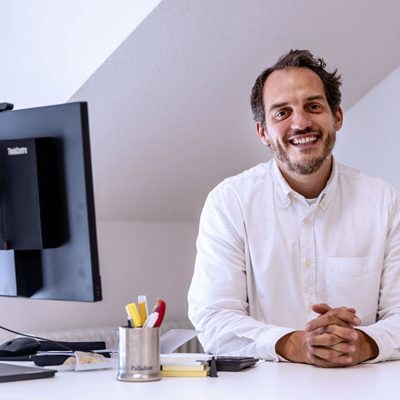 Porträt Dr. Thoren Müller am Schreibtisch, Hausarztpraxis Aachen Mitte.